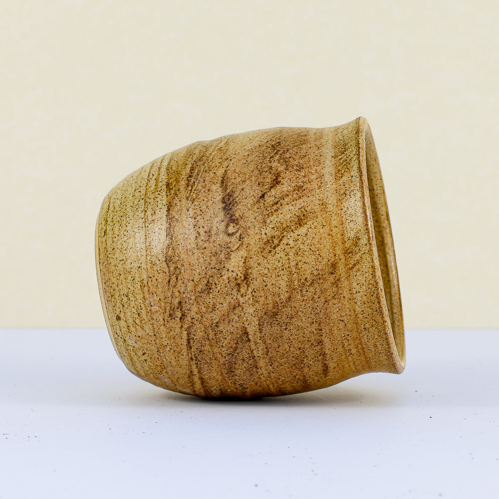 Handmade clay cup front view on its side