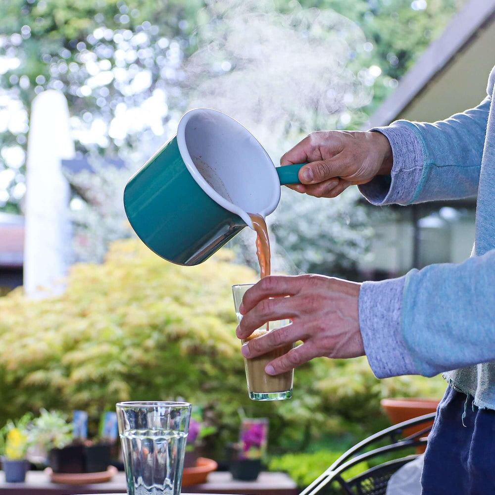 Enamel Chai Pan in action pouring chai into a cup